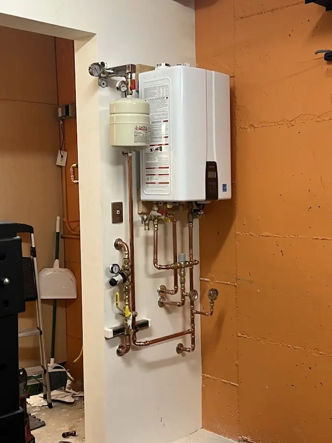Plumbing technician inspecting water heater connections in Tarboro